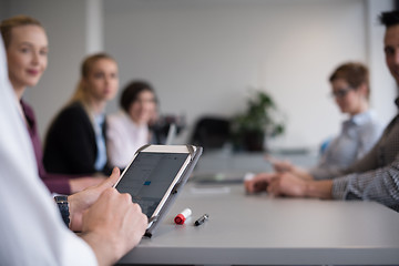 Image showing close up of  businessman hands  using tablet on meeting