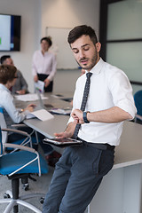 Image showing young business man with tablet at office meeting room