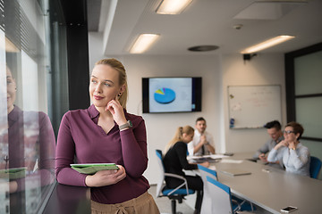 Image showing blonde businesswoman working on tablet at office