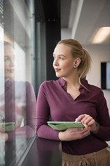 Image showing blonde businesswoman working on tablet at office