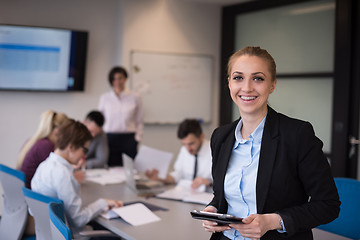 Image showing business woman working on tablet at meeting room