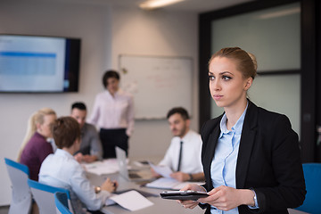 Image showing business woman working on tablet at meeting room