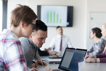 Image showing young business couple working on laptop, businesspeople group on