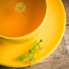 Image showing Yellow cup with linden tea on the table,  top view