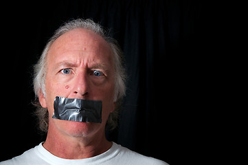 Image showing wide eyed man with duct taped mouth