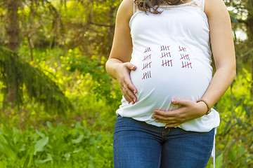 Image showing Pregnant young woman outdoors in warm summer day