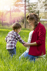 Image showing beautiful pregnant woman outdoor with her little boy