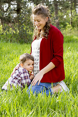 Image showing beautiful pregnant woman outdoor with her little boy