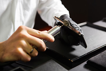 Image showing mechanical polishing of the smartphone. Male hands. 