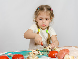 Image showing Five-year girl at the table hard cuts mushroom knife