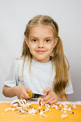 Image showing Six year old girl at a table with a knife cutting mushrooms