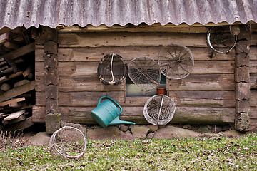 Image showing Old grunge wooden house wall with agricultural implements