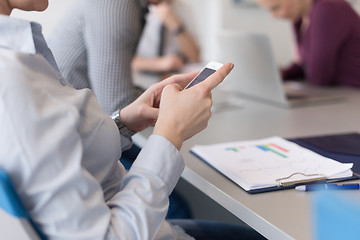 Image showing close up of  busineswoman hands  using smart phone on meeting