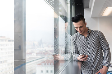 Image showing young business man using smart phone at office