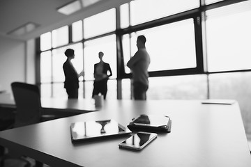 Image showing close up of tablet, business people on meeting in background