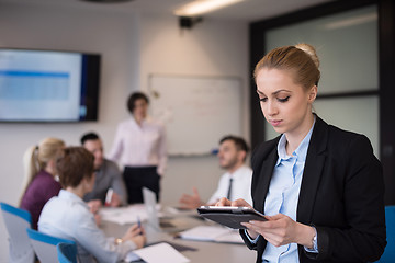 Image showing business woman working on tablet at meeting room