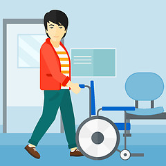 Image showing Man pushing wheelchair.