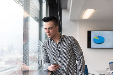 Image showing young business man using smart phone at office