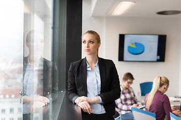 Image showing portrait of young business woman at office with team on meeting 