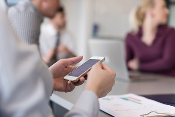 Image showing close up of  busineswoman hands  using smart phone on meeting