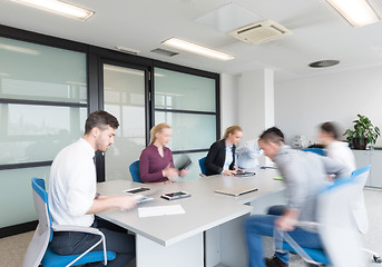 Image showing business people group entering meeting room, motion blur