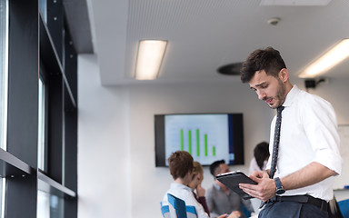 Image showing young business man with tablet at office meeting room