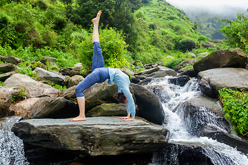 Image showing Woman doing yoga asana at waterfall