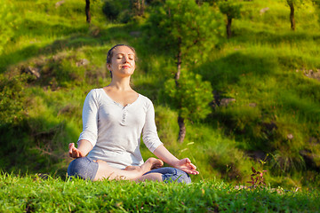 Image showing Young sporty fit woman in yoga Lotus pose oudoors 