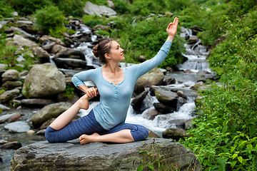 Image showing Woman doing yoga asana at tropical waterfall