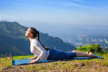 Image showing Woman practices yoga asana bhujangasana cobra pose