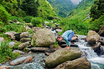 Image showing Woman doing Kakasana asana arm balance outdoors