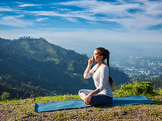 Image showing Woman practices pranayama in lotus pose outdoors