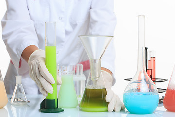 Image showing hands holding test tubes with chemical elements. 