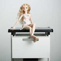 Image showing doll in a box on a light background. blurred rear plan