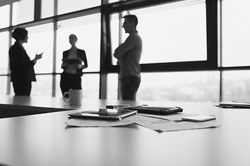 Image showing close up of tablet, business people on meeting in background