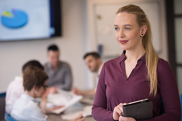 Image showing blonde businesswoman working on tablet at office