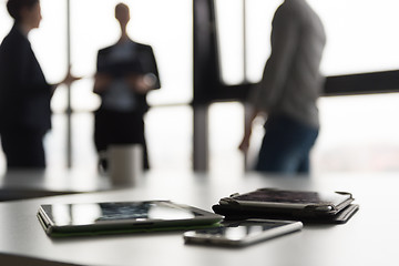 Image showing close up of tablet, business people on meeting in background