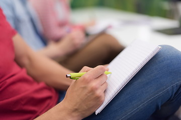 Image showing male student taking notes in classroom