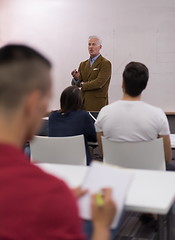 Image showing male student taking notes in classroom