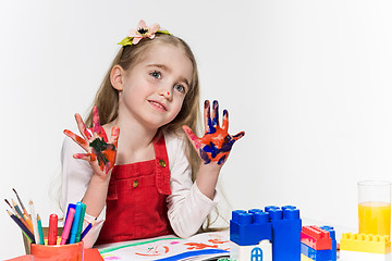 Image showing The beautiful little girl with hands in the paint