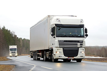 Image showing Two White Semi Trucks on Rural Road