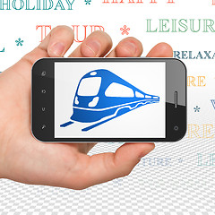 Image showing Vacation concept: Hand Holding Smartphone with Train on display