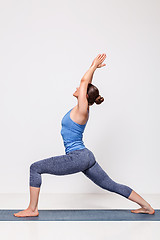 Image showing Sporty woman practices yoga Warrior pose asana 