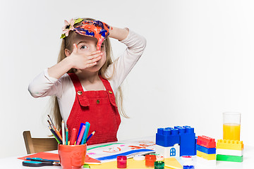 Image showing The beautiful little girl with hands in the paint