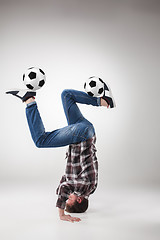 Image showing Portrait  of young man, practicing yoga with football balls