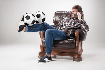 Image showing The portrait of fan with balls, holding phone on gray background