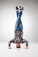 Image showing Portrait  of young man, practicing yoga with football balls