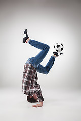 Image showing Portrait  of young man, practicing yoga with football ball