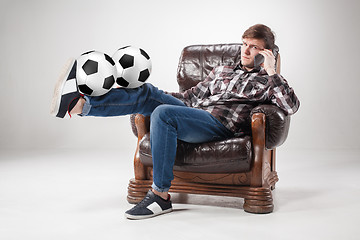 Image showing The portrait of fan with balls, holding phone on gray background