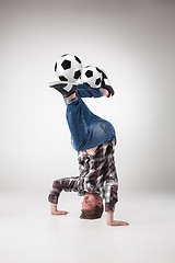 Image showing Portrait  of young man, practicing yoga with football balls